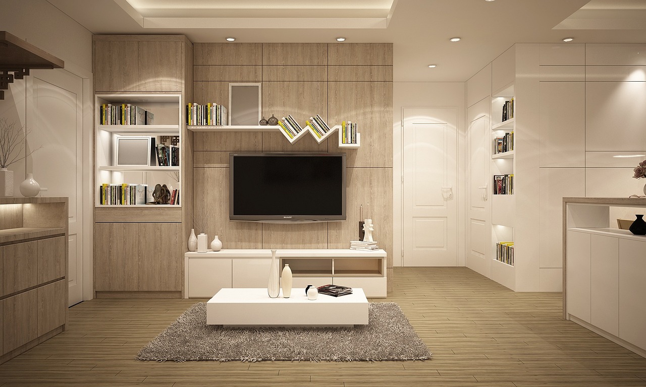 A clean contemporary living room with white furniture and wooden shelves.